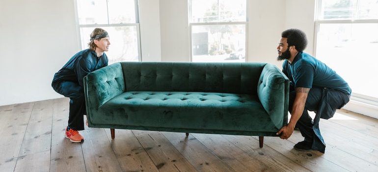 two men lifting a sofa