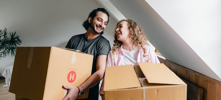 man and woman holding boxes waiting for local movers Brandon FL