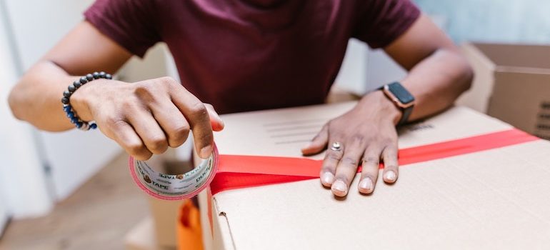 hands taping a box 