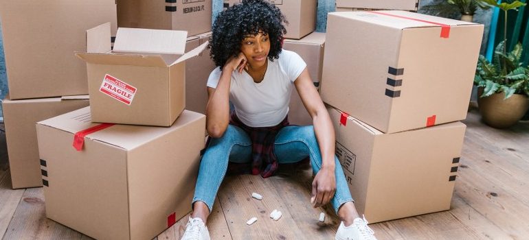 woman sitting amid cardboard boxes