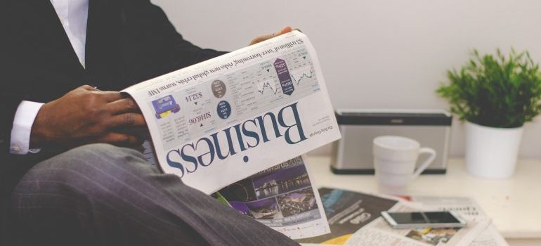 A man in a suit reading business papers. 