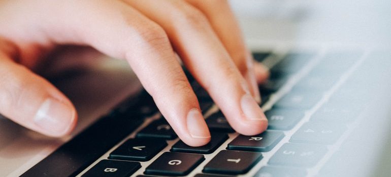 A close-up of a person typing on a keyboard.