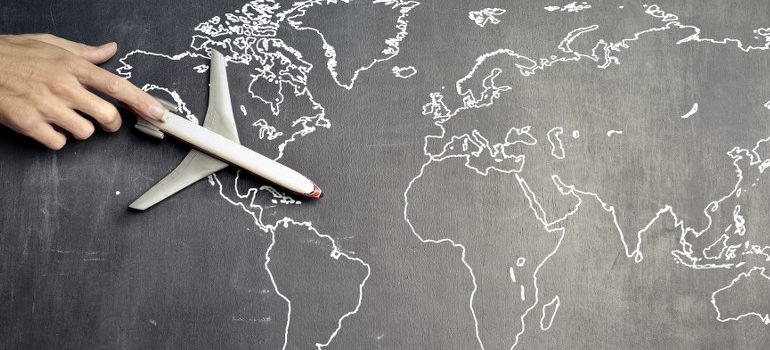 person flying a model plane over a map of the world