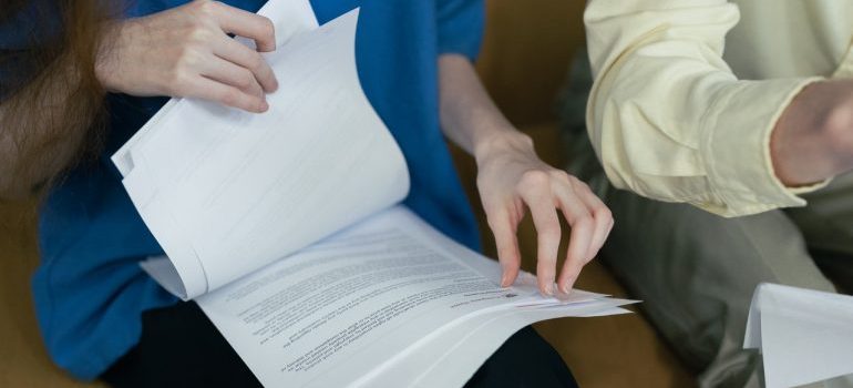 Person holding many papers.