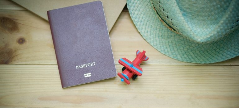 Passport, hat, and a plane toy on the table.