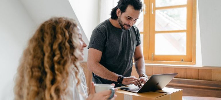 Couple comparing prices on their laptop while packing