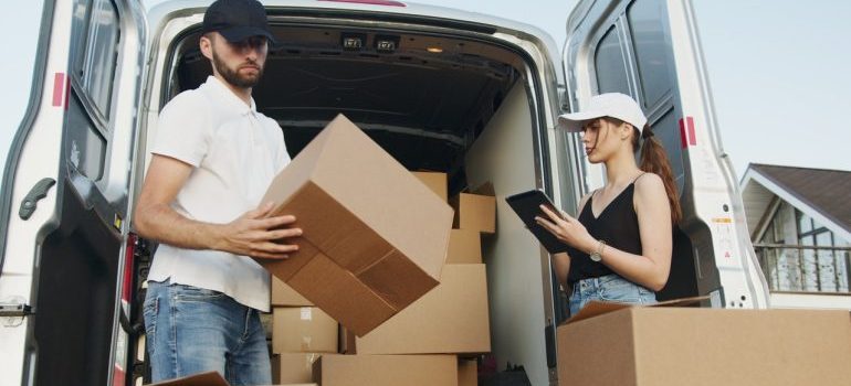 A man and woman packung moving boxes