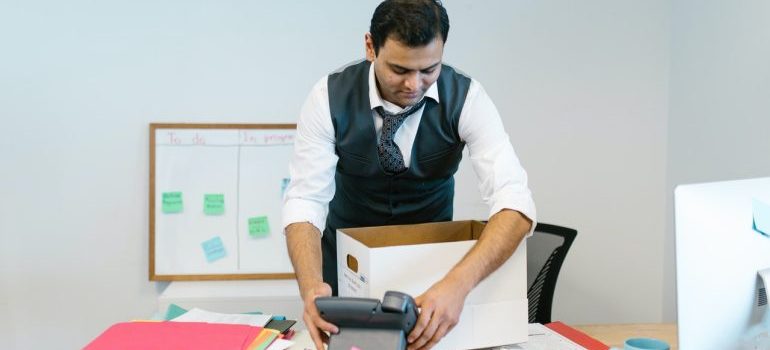 a man packing up his desk in an office