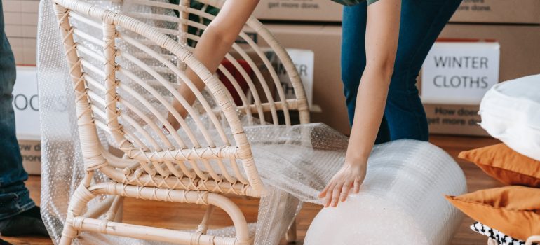 A person wrapping a chair.