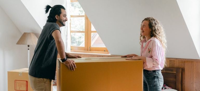 A couple having fun while packing for a move.