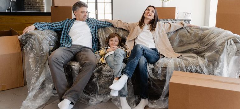 A happy family siting on the couch.