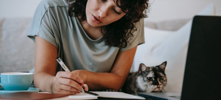 A woman with a cat doing her moving company research 