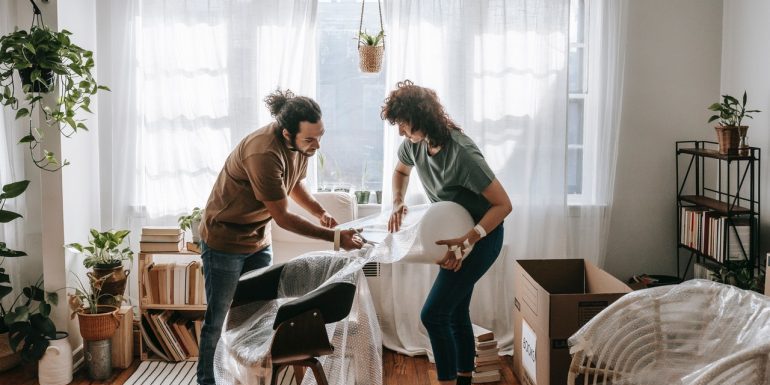 A man and a woman pack an armchair.