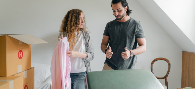 a couple being surprised at how well a piece of clothes protects items in a suitcase