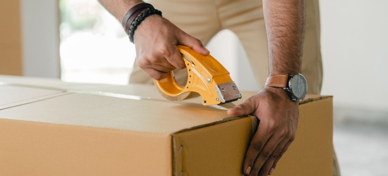 The man tapes the box.