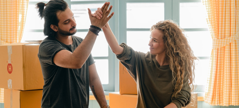 a happy couple high-fiving eachother after packing their household