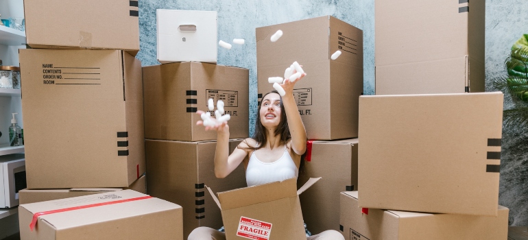 woman having fun with moving boxes