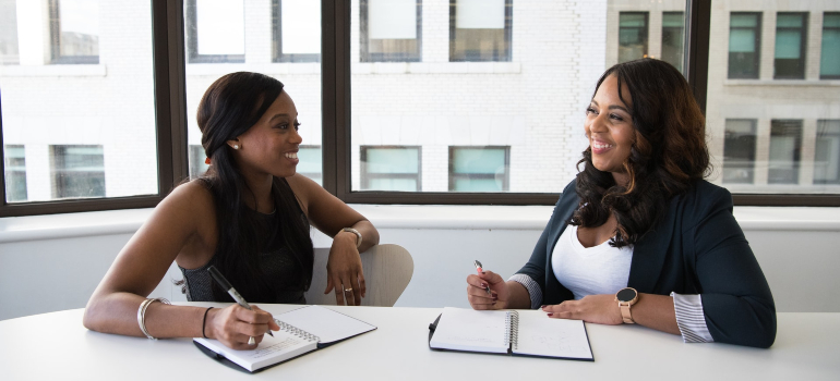 two women laughing while talking about hiring long distance movers Plantation FL