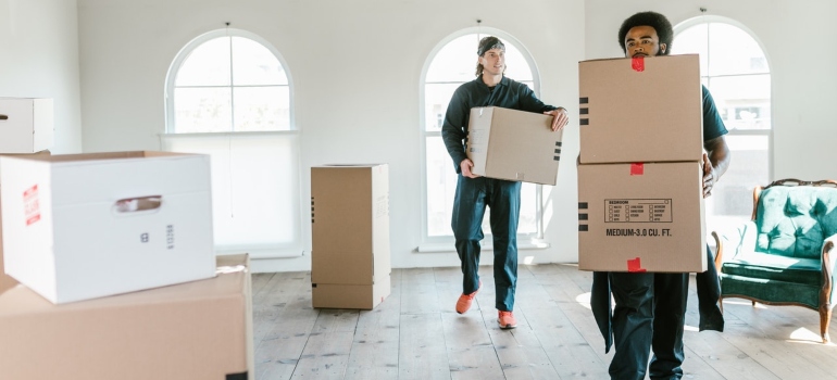 Two movers carrying boxes