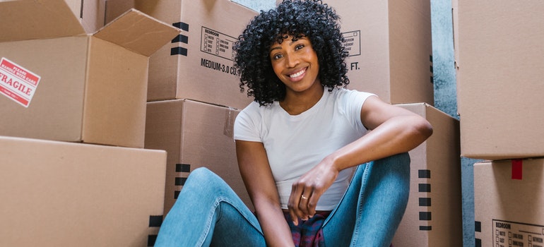 woman sitting in front of moving boxes