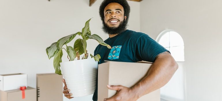 mover holding a box and a plant