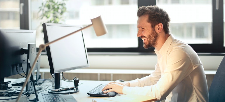 person by a computer smiling