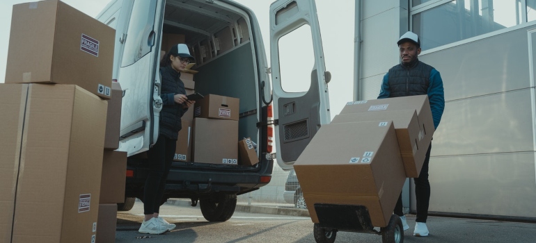 Two movers unloading items from a moving truck