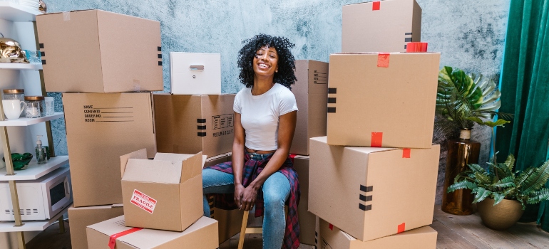 smilling black woman surrounded by cardboard boxes