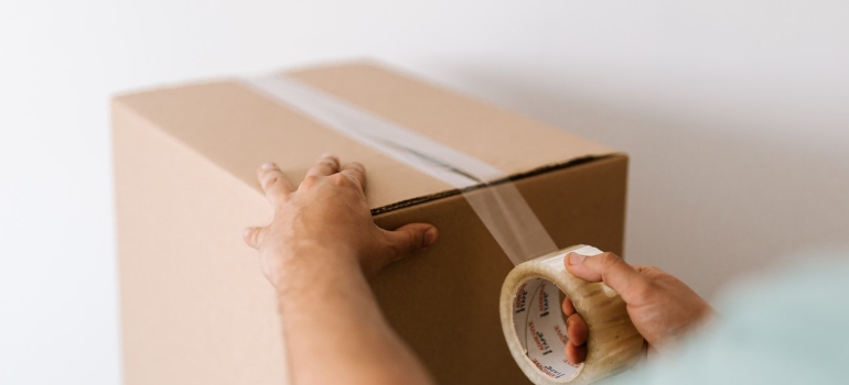 residential movers Orange Park FL wrapping tape around a moving box