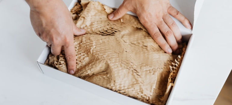 hands putting paper on a box