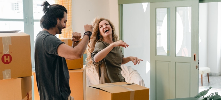 a man and a woman laughing among boxes ready for relocating