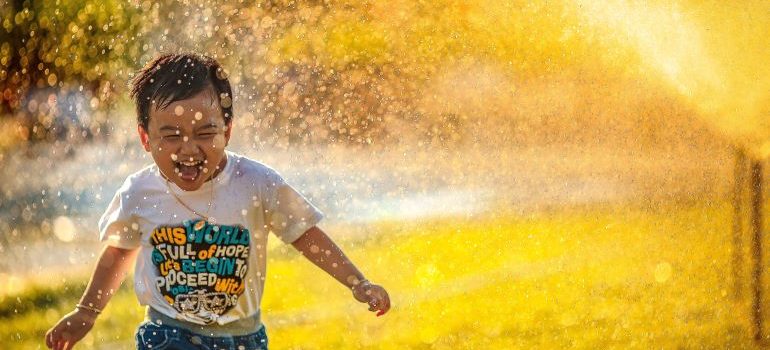 happy child running thourgh sprinklers on a hot and sunny fay in Florida