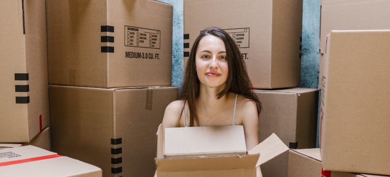 woman sitting surrounded with packing boxes