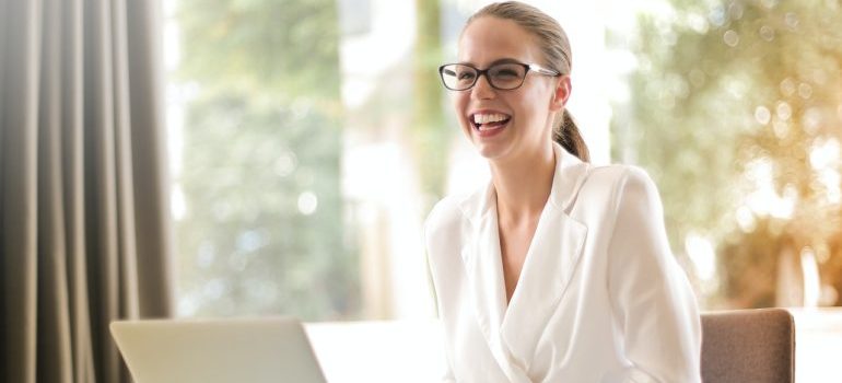 Moving to Miami Beach for a job can be a great way to start your career - young woman in office in front of laptop