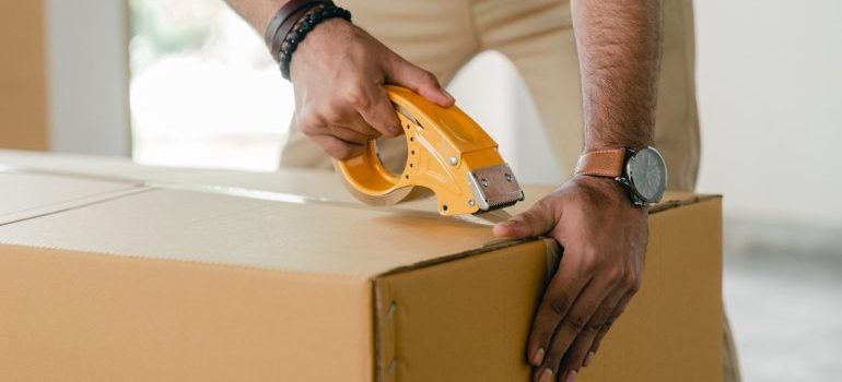 man taping a moving box