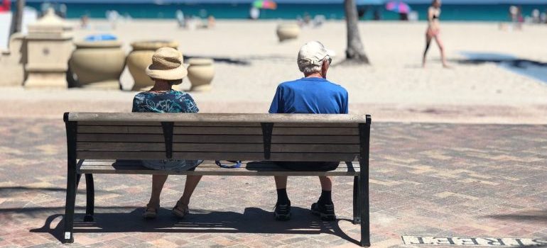 Elderly couple sitting on the bench at the beach