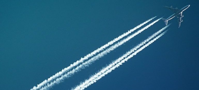 an airplane flying over the ocean with passengers that are moving to Key West FL internationally