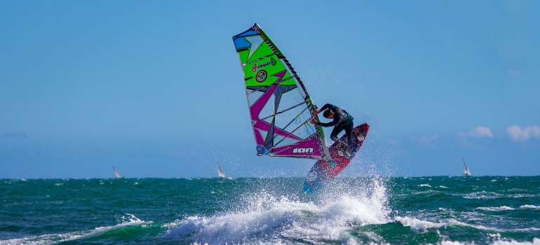 A jump in windsurfs on a sunny day without clouds.