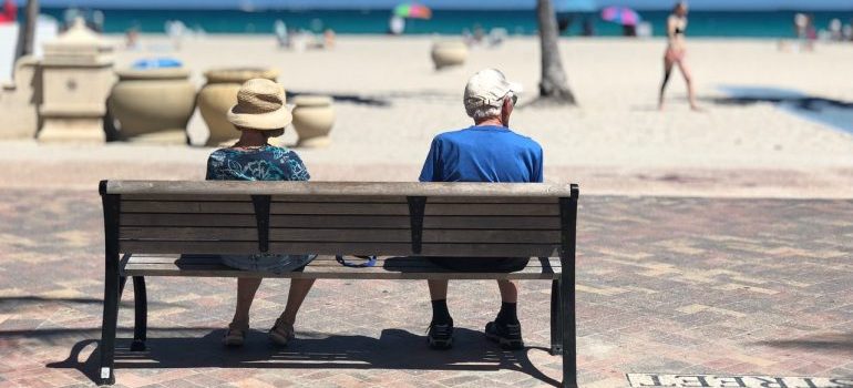 Elderly couple sitting on the bench at Florida beach