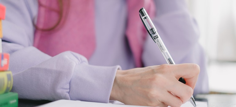 A woman writing in notebook. 