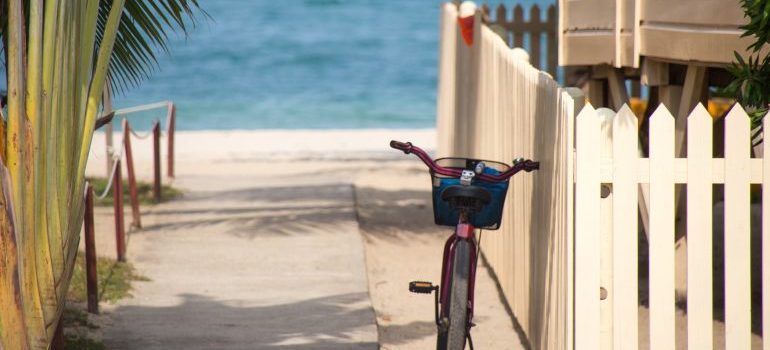 Bicycle rests against a beach house fence in Florida as outdoor activities all year round are reason why people move to Florida