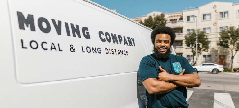 a moving company truck and a man standing next to it, smiling
