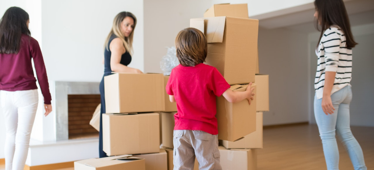 A boy holding moving boxes