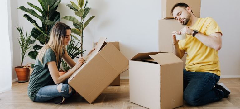 Man and woman labeling and packing boxes