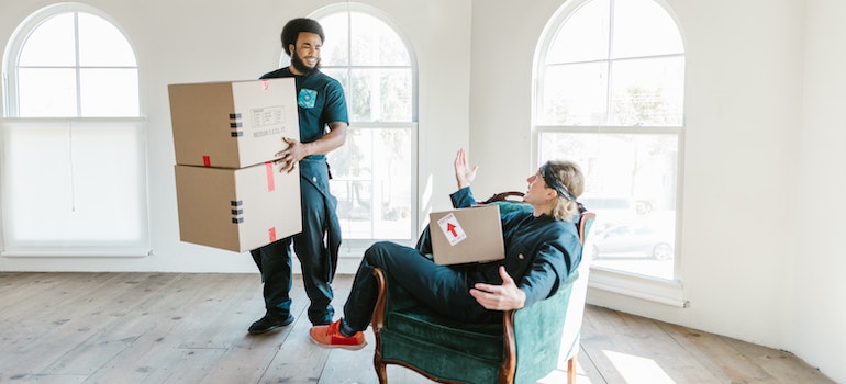 Men in green working suits holding boxes