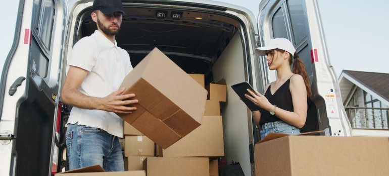 a man and a woman packing boxes