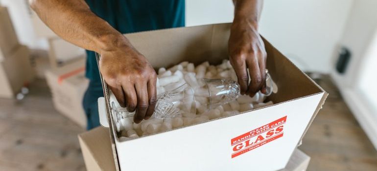 Professional mover packing glass in the moving box