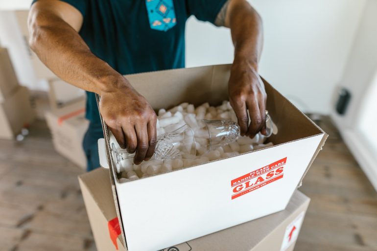 Professional packer packing glass in box