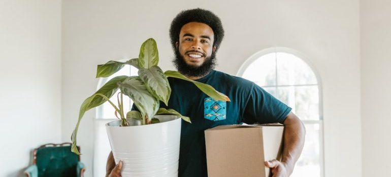 Man with box and plant