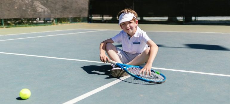 Boy on the tennis court in one of the best Florida cities with most sports opportunities